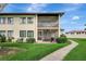 Exterior view of this 2-story home featuring a screened lanai, outdoor grill and lush green lawn and landscaping at 4646 Longwater Chase # 98, Sarasota, FL 34235