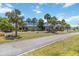 Community clubhouse with blue tile roof, beautiful landscaping, and palm tree lined street at 491 Cervina Dr, Venice, FL 34285