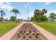 Community center with lush landscaping, American flag, and inviting walking path at 491 Cervina Dr, Venice, FL 34285