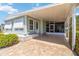 Inviting exterior with a covered carport, screened room and well-maintained landscaping, and brick paved drive way at 491 Cervina Dr, Venice, FL 34285