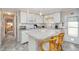 Bright kitchen with white cabinets, modern appliances, and an island, with open view into the bedroom at 491 Cervina Dr, Venice, FL 34285