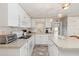 Functional kitchen with white appliances, ample counter space, and abundant cabinet storage with bright lighting at 491 Cervina Dr, Venice, FL 34285
