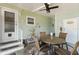 Charming covered patio with dining set, ceiling fan, and cozy outdoor living space at 491 Cervina Dr, Venice, FL 34285