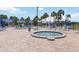 Community pool and hot tub area with brick pavers and surrounding palm trees at 491 Cervina Dr, Venice, FL 34285