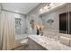 Bright bathroom featuring a marble countertop vanity, a large mirror, and a shower-tub combination at 5140 Administration St, Port Charlotte, FL 33948