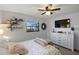 Relaxing bedroom featuring stylish decor, a ceiling fan, a large television, and a bright window view at 5140 Administration St, Port Charlotte, FL 33948