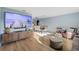 Open-concept living room featuring wood floors, a large flat screen TV, and ample natural light at 5140 Administration St, Port Charlotte, FL 33948
