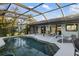 Enjoy lounging by this screened-in pool with outdoor dining, lounge chairs, and lush tropical landscaping at 5140 Administration St, Port Charlotte, FL 33948