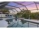 Enjoy evening swims in this screened-in pool with an outdoor kitchen and bar, perfect for entertaining and relaxation at 5140 Administration St, Port Charlotte, FL 33948