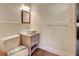Updated half bath with a vessel sink, wooden mirror, and stylish toilet in a neutral color palette at 602 Bonito Ave, Nokomis, FL 34275