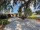 Long driveway lined with mature trees and tropical landscaping leading to the house at 602 Bonito Ave, Nokomis, FL 34275