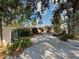 Lush, tree-lined driveway leading to a cozy home with tropical foliage at 602 Bonito Ave, Nokomis, FL 34275