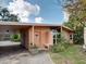 Inviting home entrance with covered parking, an outdoor bench, and tropical greenery at 602 Bonito Ave, Nokomis, FL 34275