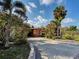 Charming single story home with a concrete driveway and lush tropical landscaping at 602 Bonito Ave, Nokomis, FL 34275