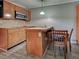 Cozy kitchenette with wood cabinets, tile backsplash, stainless steel microwave and dining table with chairs at 602 Bonito Ave, Nokomis, FL 34275