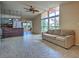 Open-concept living room with a large windows, ceiling fan, and access to the kitchen at 602 Bonito Ave, Nokomis, FL 34275