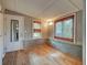 Cozy living room with wood floors, brick accents, and natural light from two windows with woven blinds at 602 Bonito Ave, Nokomis, FL 34275