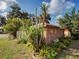 Backyard features a utility shed with lattice, complemented by tropical plants and greenery at 602 Bonito Ave, Nokomis, FL 34275