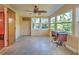 Bright sunroom with large windows offering views of the yard, a ceiling fan, and an antique sewing table at 602 Bonito Ave, Nokomis, FL 34275