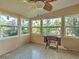 Light-filled sunroom with multiple windows showcasing the garden views, vintage sewing machine, and ceiling fan at 602 Bonito Ave, Nokomis, FL 34275