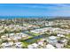 Wide aerial view of canal front homes near the ocean with tree-lined streets in a waterside community at 608 Fair Winds Dr # 608, Nokomis, FL 34275