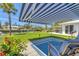 Waterfront backyard featuring an awning covered patio and lush landscaping at 608 Fair Winds Dr # 608, Nokomis, FL 34275