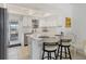 Bright kitchen featuring white cabinets, stainless steel appliances, and convenient breakfast bar seating at 608 Fair Winds Dr # 608, Nokomis, FL 34275