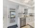 Well-lit kitchen with stainless steel dishwasher, white cabinets, and access to the outdoor area at 608 Fair Winds Dr # 608, Nokomis, FL 34275