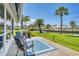 Inviting waterfront patio with comfortable seating, lush landscaping, and serene water views at 608 Fair Winds Dr # 608, Nokomis, FL 34275