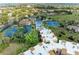 Bright aerial view of residences featuring a pool, tennis courts, and well-maintained landscaping at 618 Bird Bay S Dr # 110, Venice, FL 34285