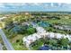 A sunny aerial view of residences with tennis courts, pool, and clubhouse amenities at 618 Bird Bay S Dr # 110, Venice, FL 34285