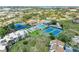 An aerial view showcasing residences with access to a pool and multiple tennis courts at 618 Bird Bay S Dr # 110, Venice, FL 34285