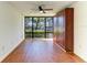 Bedroom featuring a ceiling fan, wood floors, and a large window overlooking the parking area at 618 Bird Bay S Dr # 110, Venice, FL 34285