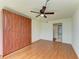 Bedroom featuring a ceiling fan, wood floors, and a large built in wardrobe at 618 Bird Bay S Dr # 110, Venice, FL 34285