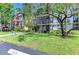 Attractive condo building with well-manicured lawn, mature trees and an American flag at 618 Bird Bay S Dr # 110, Venice, FL 34285