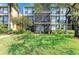 Multi-story condo building featuring lush landscaping and screened-in balconies at 618 Bird Bay S Dr # 110, Venice, FL 34285