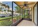 Cozy screened patio with a ceiling fan and views of the well-maintained community landscaping and parking at 618 Bird Bay S Dr # 110, Venice, FL 34285