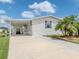 Charming home featuring an attached carport, a well-maintained lawn, and mature palm trees at 700 Blackburn Blvd, North Port, FL 34287