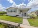 Home featuring a covered outdoor space with a grill, a well-maintained lawn, and mature landscaping at 700 Blackburn Blvd, North Port, FL 34287