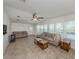 Bright living room with neutral tile floors, ceiling fan, and large windows overlooking water at 700 Blackburn Blvd, North Port, FL 34287