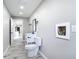 Bathroom with a toilet and vanity, along with the entrance, featuring a consistent wood-look floor at 7140 Teaberry St, Englewood, FL 34224