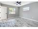 Bright bedroom with wood-look flooring, ceiling fan, and natural light from windows at 7140 Teaberry St, Englewood, FL 34224