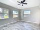 This bedroom features lots of natural light, ceiling fan and wood-look tile flooring at 7140 Teaberry St, Englewood, FL 34224