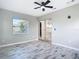 Bright bedroom with wood-look tile flooring, a ceiling fan and sliding mirrored closet doors at 7140 Teaberry St, Englewood, FL 34224