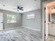 Stylish bedroom featuring wood-look flooring and ceiling fan, with a glimpse of the adjacent bathroom at 7140 Teaberry St, Englewood, FL 34224