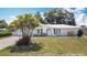Well-maintained home with a lush front yard, mature palm trees, and a double-car garage at 7140 Teaberry St, Englewood, FL 34224