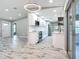 Bright, open kitchen with white cabinetry, stainless steel appliances, and wood-look tile floors at 7140 Teaberry St, Englewood, FL 34224