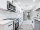 Close up of a modern kitchen featuring white cabinets, stainless steel appliances, and white subway tile backsplash at 7140 Teaberry St, Englewood, FL 34224