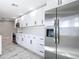 Spacious kitchen with stainless steel refrigerator, white cabinets, and modern appliances at 7140 Teaberry St, Englewood, FL 34224