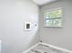Clean laundry room area with a window that provides natural light and neutral walls at 7140 Teaberry St, Englewood, FL 34224